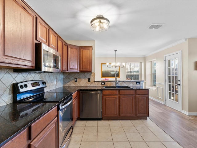 kitchen featuring sink, tasteful backsplash, crown molding, kitchen peninsula, and stainless steel appliances