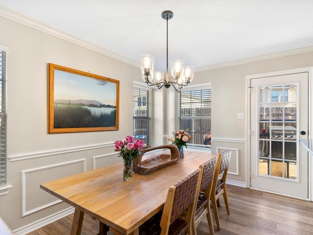 dining area featuring ornamental molding, a chandelier, and hardwood / wood-style floors