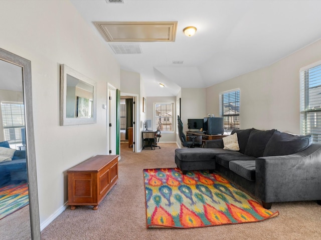 living room with a wealth of natural light, vaulted ceiling, and light colored carpet