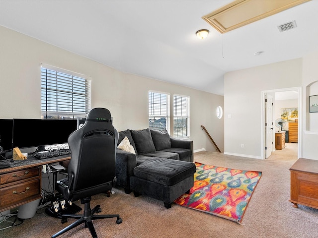 home office with vaulted ceiling and light carpet