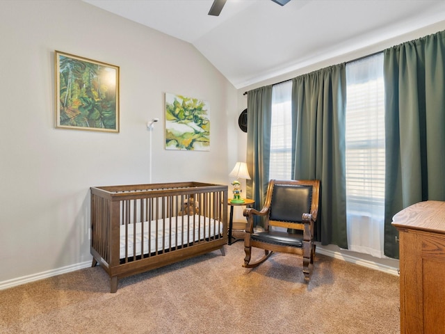 bedroom with a nursery area, ceiling fan, vaulted ceiling, and carpet