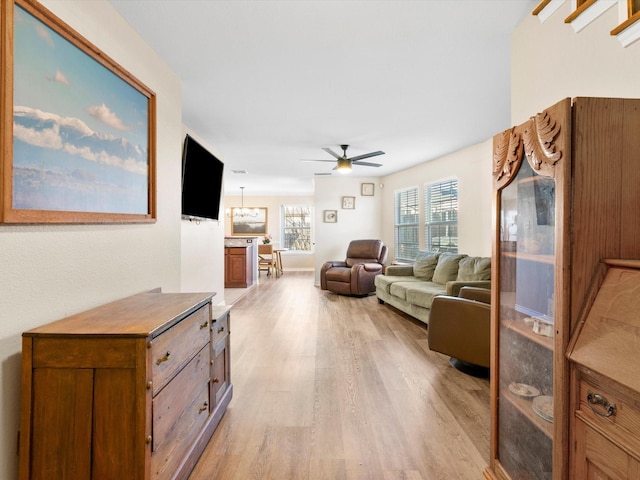 living room featuring ceiling fan and light hardwood / wood-style floors