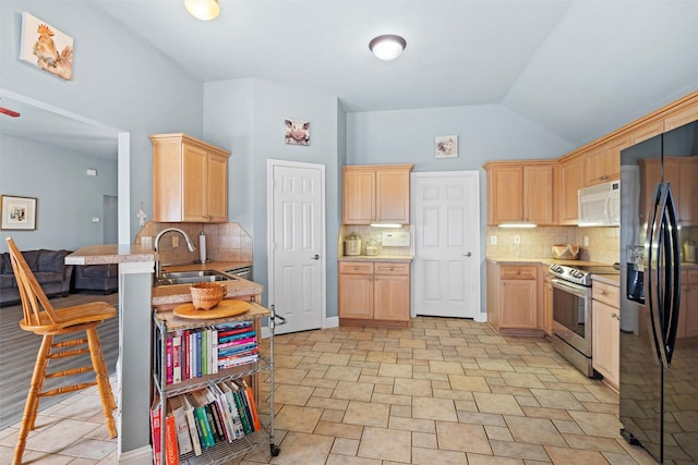 kitchen featuring sink, stainless steel electric range oven, black refrigerator with ice dispenser, light brown cabinets, and kitchen peninsula