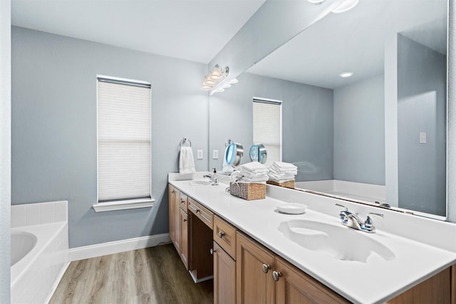 bathroom with vanity, a bathing tub, and hardwood / wood-style floors