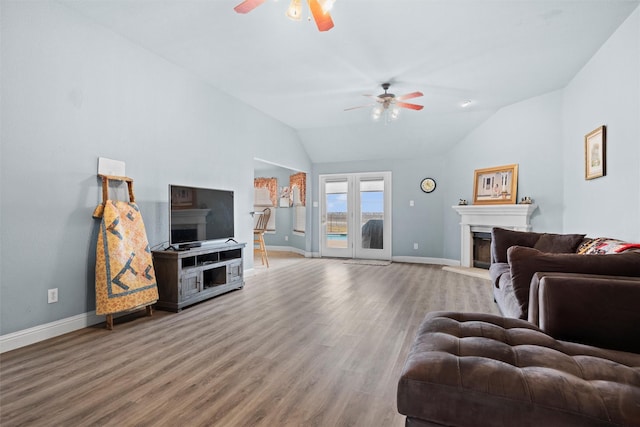 living room with ceiling fan, wood-type flooring, and lofted ceiling