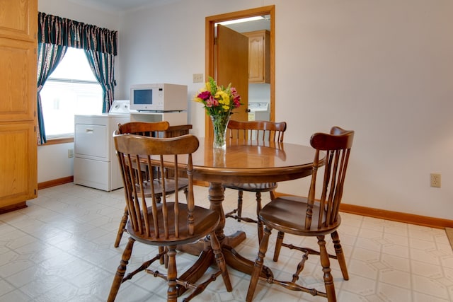 dining room with washer / dryer and ornamental molding