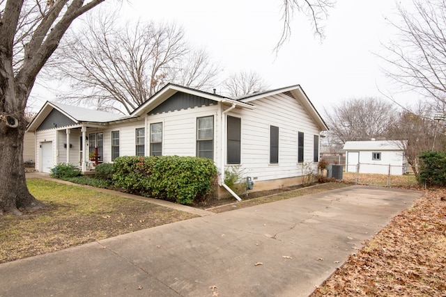 view of side of home featuring cooling unit and a garage