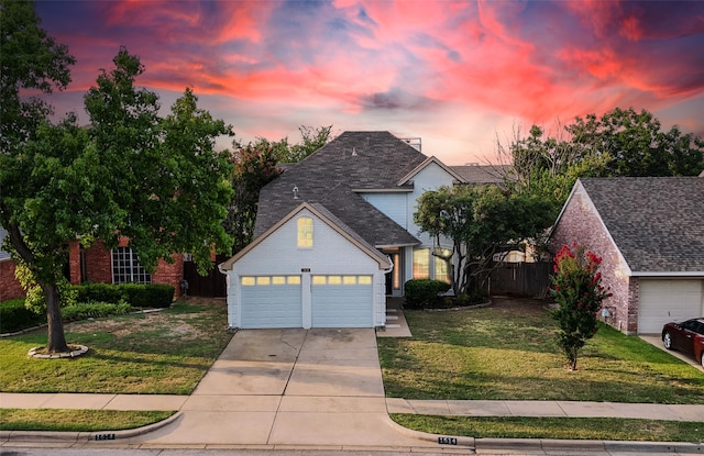 view of property with a garage and a lawn