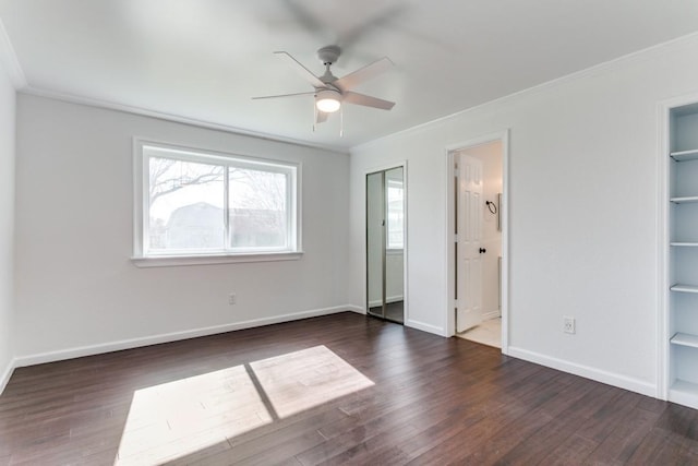 unfurnished bedroom with ornamental molding, ensuite bath, wood finished floors, and baseboards