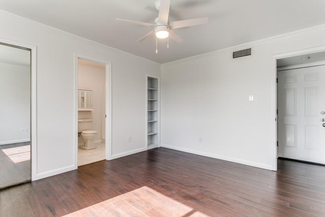 unfurnished bedroom with wood finished floors, visible vents, and crown molding