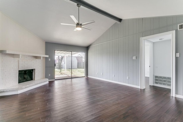 unfurnished living room with ceiling fan, dark hardwood / wood-style floors, a brick fireplace, and vaulted ceiling with beams