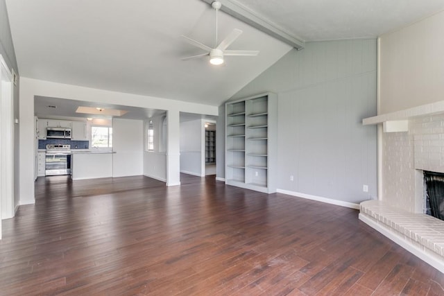 unfurnished living room with lofted ceiling with beams, a brick fireplace, dark wood-type flooring, and ceiling fan