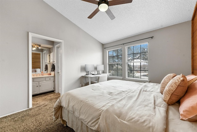 bedroom featuring sink, ensuite bath, carpet flooring, a textured ceiling, and vaulted ceiling