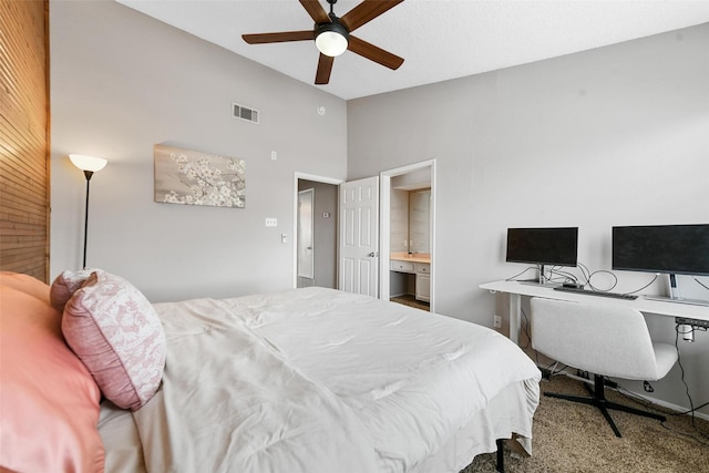 carpeted bedroom with vaulted ceiling, ceiling fan, and ensuite bath