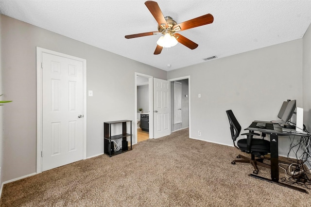 carpeted office space with ceiling fan and a textured ceiling