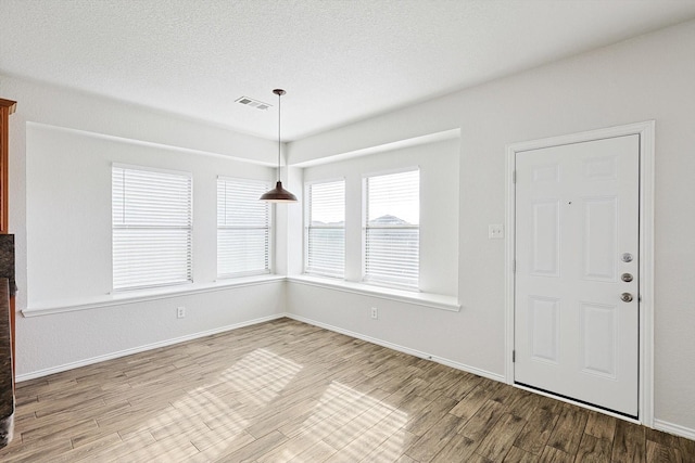 interior space featuring wood-type flooring and a textured ceiling