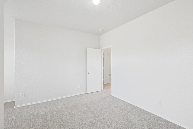 carpeted empty room with a textured ceiling