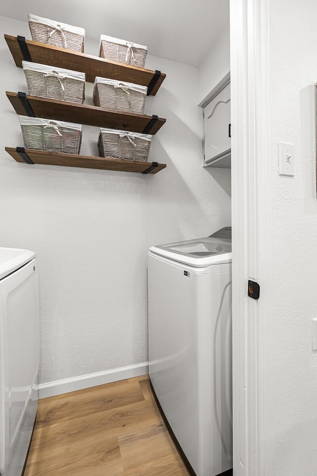 laundry room featuring washer and dryer and light wood-type flooring