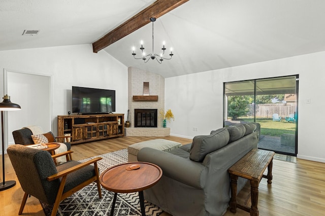 living room featuring a brick fireplace, a notable chandelier, lofted ceiling with beams, and light hardwood / wood-style floors