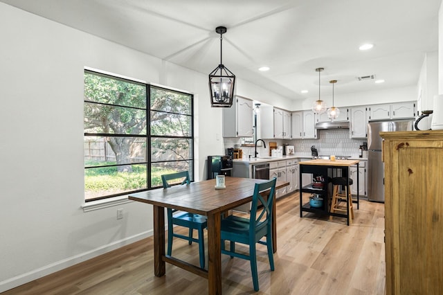 dining area with sink and light hardwood / wood-style flooring