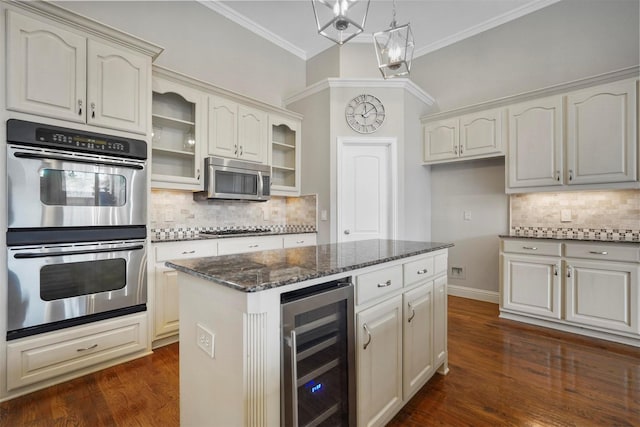 kitchen with stainless steel appliances, wine cooler, a kitchen island, dark hardwood / wood-style flooring, and dark stone counters