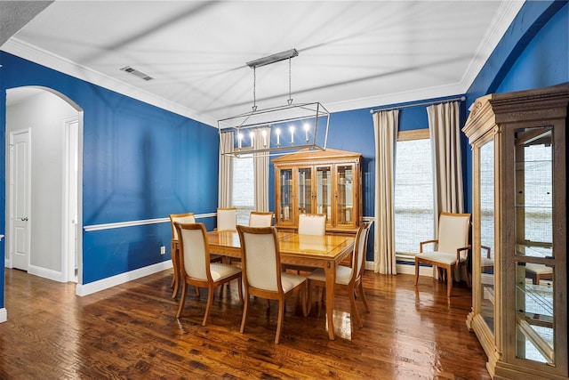 dining space featuring ornamental molding, dark hardwood / wood-style flooring, and a notable chandelier