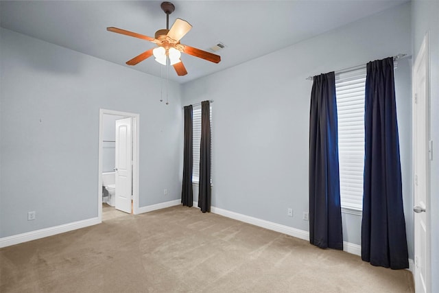 unfurnished bedroom with light colored carpet, ceiling fan, and ensuite bathroom