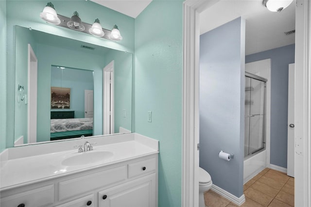 full bathroom featuring bath / shower combo with glass door, vanity, tile patterned floors, and toilet