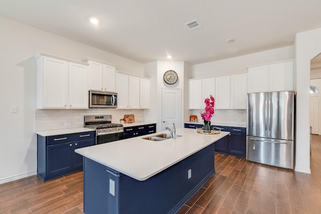 kitchen featuring blue cabinets, appliances with stainless steel finishes, sink, and a kitchen island with sink