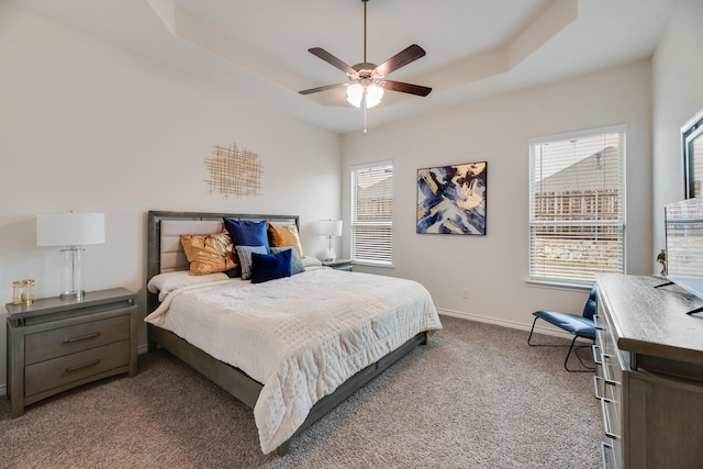 bedroom featuring carpet floors, a raised ceiling, and ceiling fan