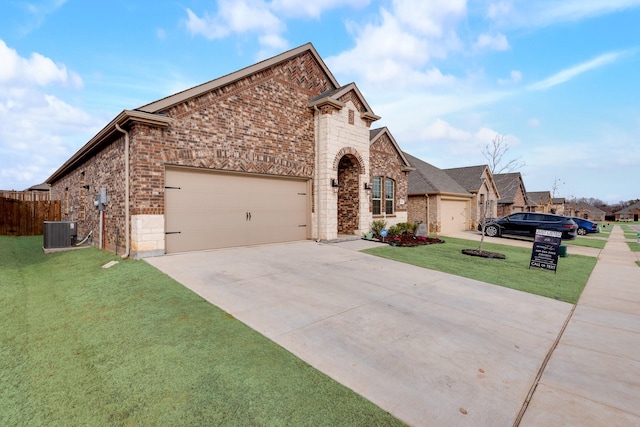 view of front of home with central AC, a garage, and a front lawn