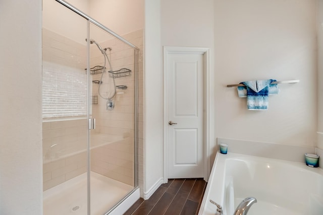 bathroom featuring wood-type flooring and shower with separate bathtub