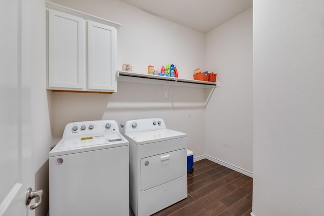 clothes washing area featuring cabinets and separate washer and dryer