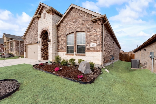 view of front facade with central AC, a garage, and a front lawn