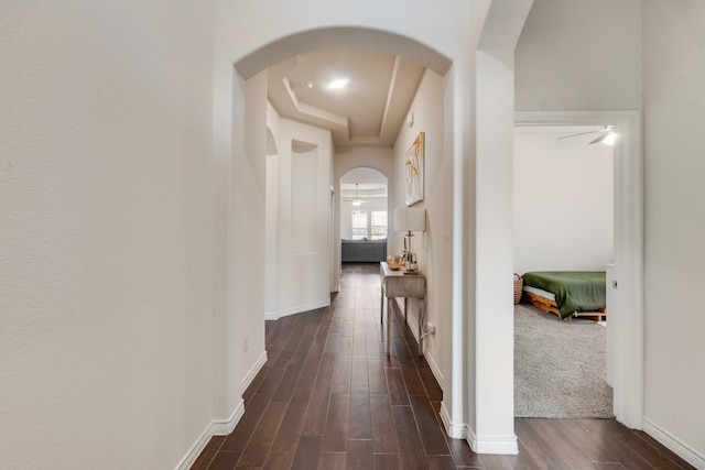 hall with dark hardwood / wood-style flooring and a tray ceiling