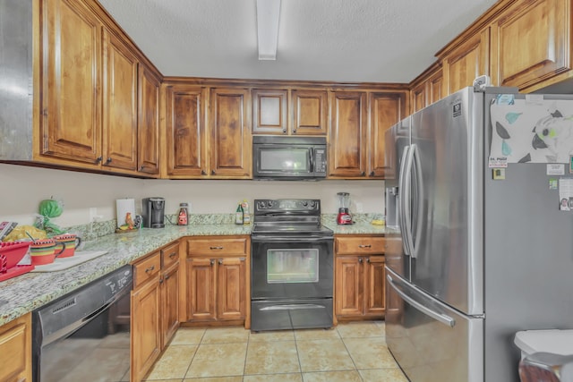 kitchen with light stone counters, black appliances, a textured ceiling, and light tile patterned flooring