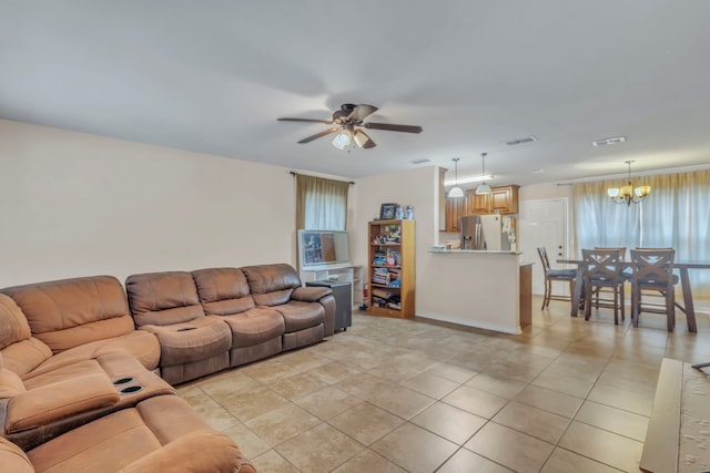 tiled living room with ceiling fan with notable chandelier