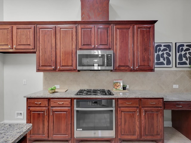 kitchen featuring tasteful backsplash, light stone countertops, and appliances with stainless steel finishes