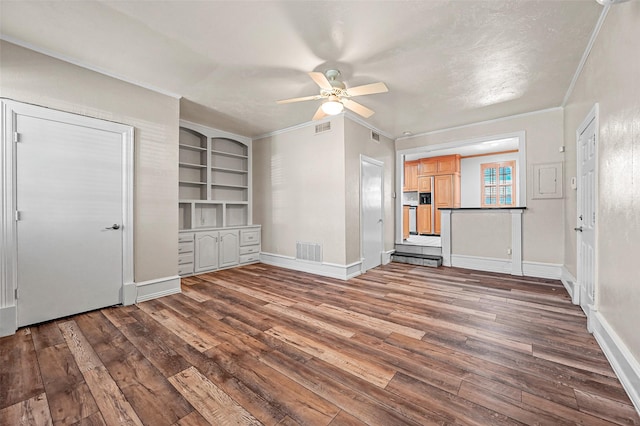 unfurnished living room featuring crown molding, built in features, dark hardwood / wood-style floors, and ceiling fan