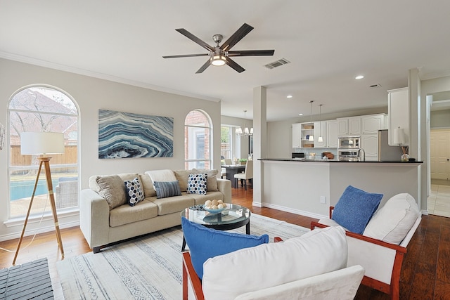 living room featuring ceiling fan with notable chandelier, ornamental molding, and light hardwood / wood-style floors