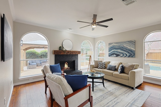 living room with crown molding, light hardwood / wood-style floors, and a wealth of natural light