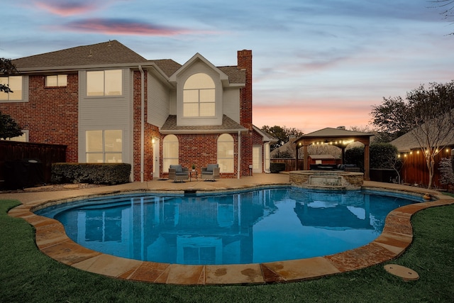 pool at dusk with a gazebo, a patio, and an in ground hot tub