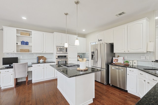 kitchen with stainless steel appliances, white cabinetry, a center island, and decorative light fixtures