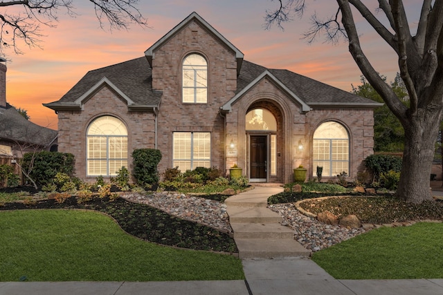 french provincial home with a lawn