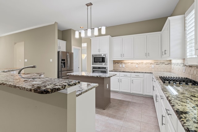 kitchen featuring light stone counters, a center island, pendant lighting, stainless steel appliances, and white cabinets