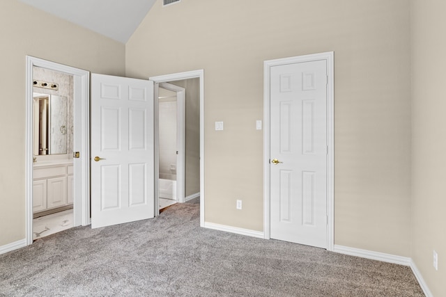 unfurnished bedroom featuring vaulted ceiling, carpet floors, and ensuite bathroom