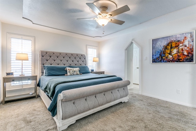 bedroom featuring light carpet, a textured ceiling, and ceiling fan