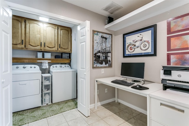 laundry room with washer and dryer, cabinets, and light tile patterned flooring