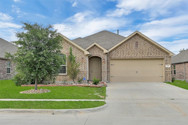 view of front of property featuring a garage and a front lawn