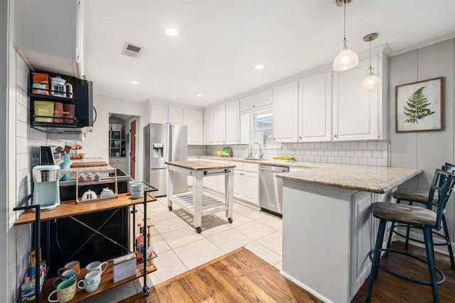 kitchen featuring white cabinetry, light stone countertops, and stainless steel appliances